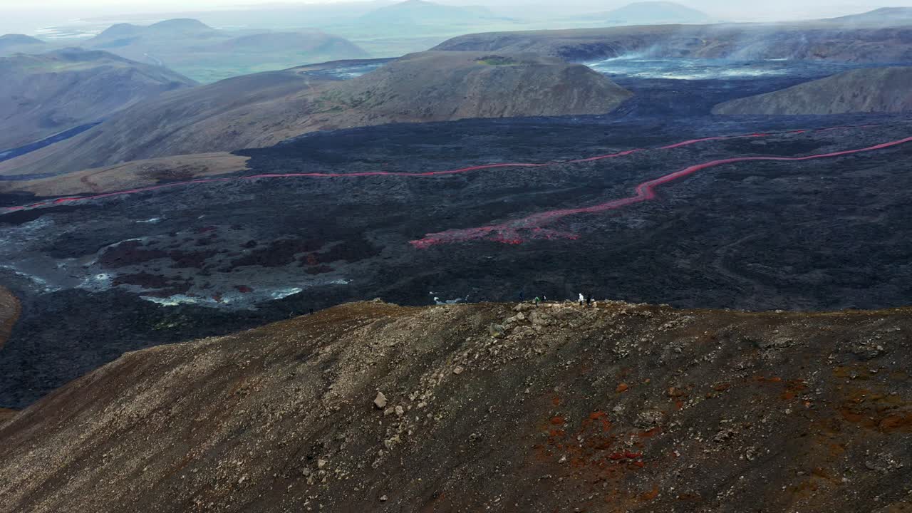 personas que visitan el volcán activo, el monte fagradalsfjall, islandia - toma aérea de drones