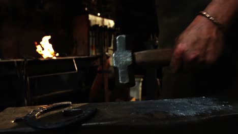 mid-section of blacksmith holding hammer