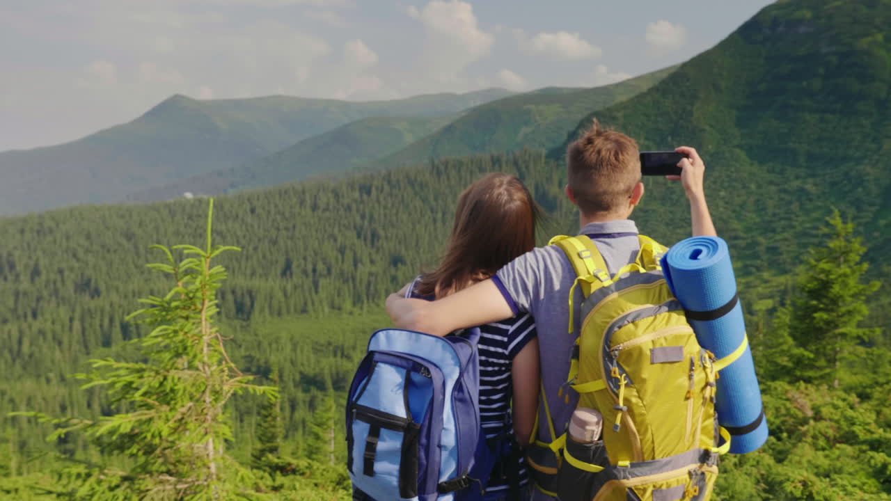 amigos fotografían un hermoso paisaje de montaña disfrutan del descanso juntos vista posterior video 4k