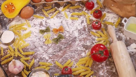 hand arranging pasta, tomato and onion in a well ordered fashion on a table