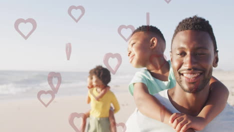 carrying child on beach, father with heart animation overlay in background