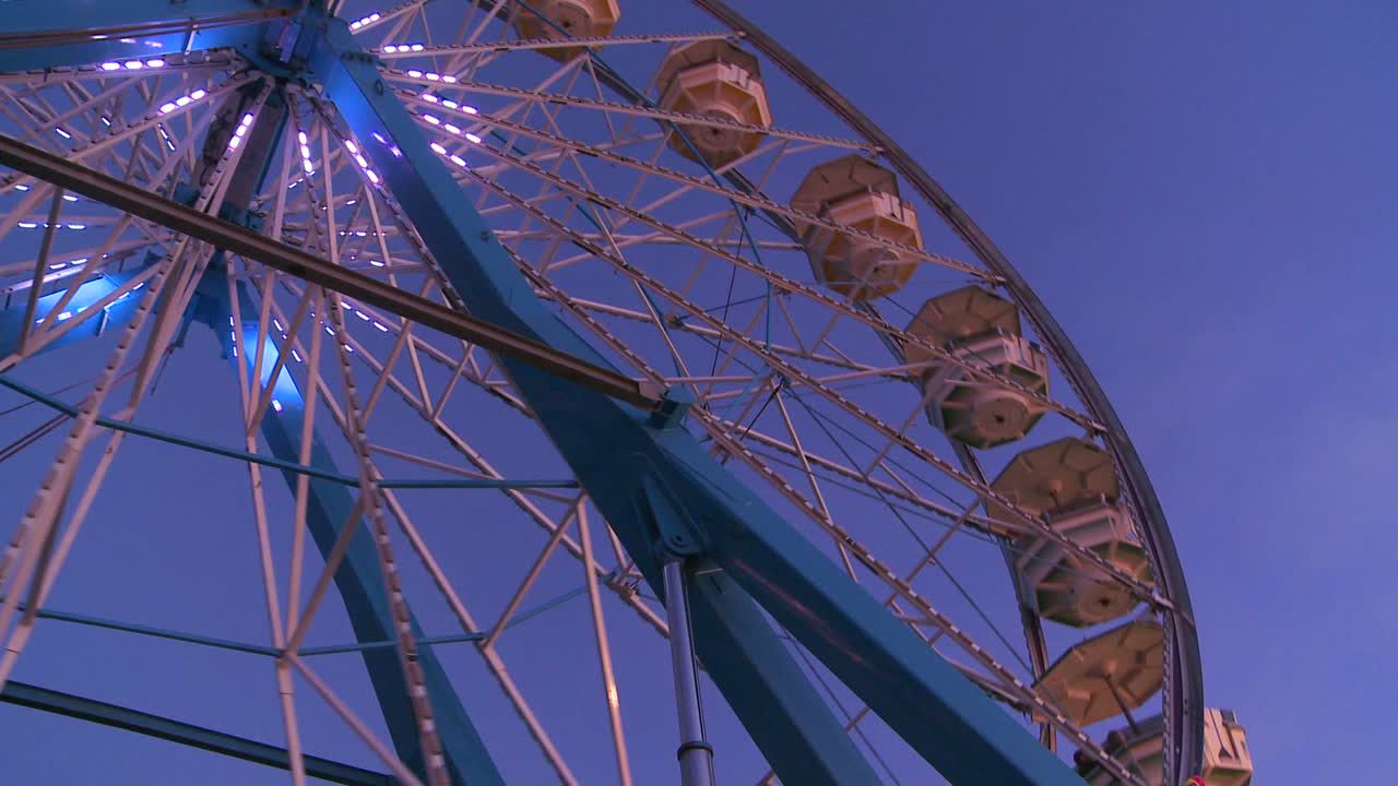 una rueda de la fortuna gira y está brillantemente iluminada