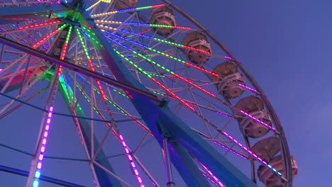 a ferris wheel spins and is brightly lit