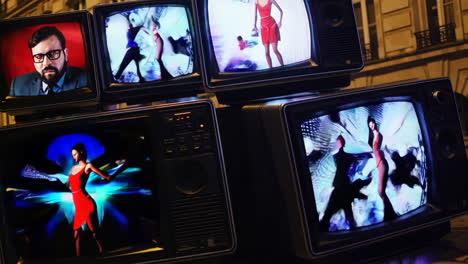 stacked vintage televisions displaying fashion show images