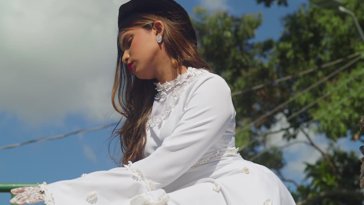 A child adorned in a vintage wedding dress amidst the majestic walls of a fort.