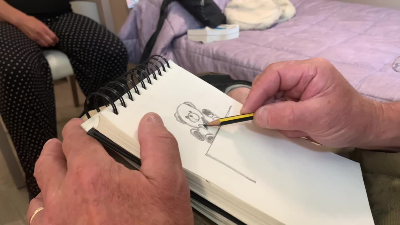 Man Draws a Teddy Bear on Sketchbook