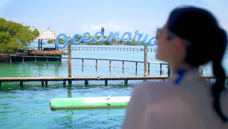 Plano-Medio-De-Una-Chica-Con-Gafas-De-Sol-Azules-Mirando-El-Océano-En-Un-Oceanario-En-Cartagena-Colombia-1