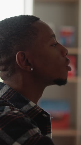 el estudiante toma un libro del estante de la biblioteca. el hombre afroamericano encuentra un libro de texto para escribir la tesis en el centro de información de la universidad. el chico elige una novela