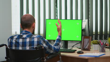 Businessman-in-wheelchair-using-computer-with-chroma-key