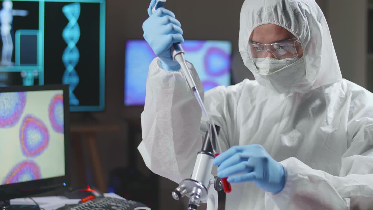 Asian Doctor In Protective Suit Is Doing A Science Experiments And Developing Vaccine In A Modern Lab. Laboratory Assistant Workplace. The Concept Of Science And Medicine