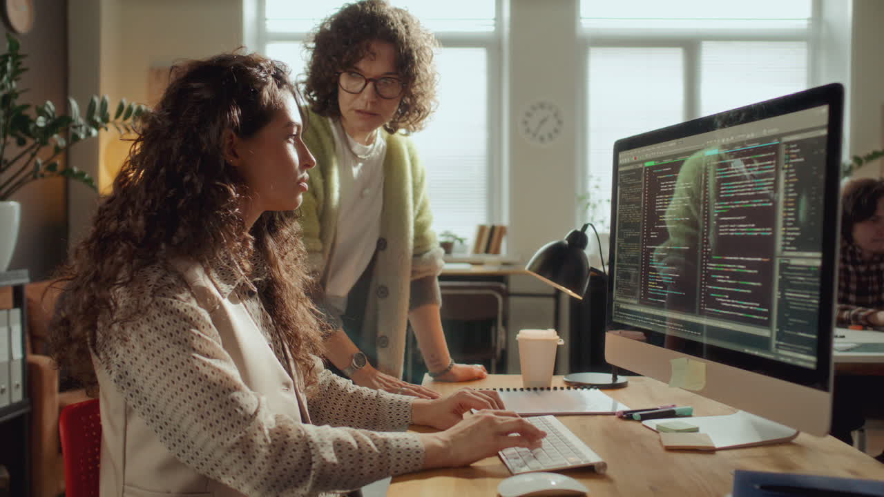 Female IT Specialists Collaborating on Software Development in Office