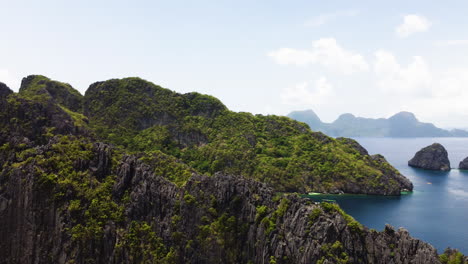 aerial of rugged cliffs along palawan revealing idyllic lagoon