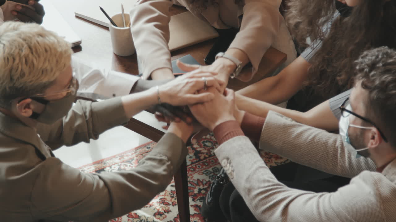 Cheerful Colleagues in Masks Putting Hands Together in Middle