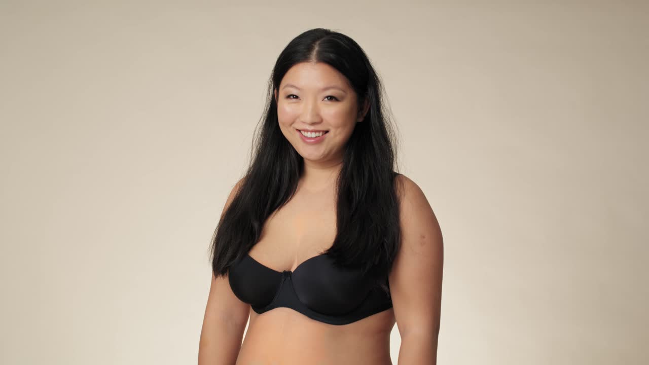 Ritratto di donna cinese sorridente in intimo in studio