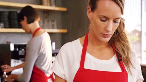 Waitress-using-digital-tablet-at-counter