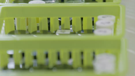 test tubes are stored in laboratory racks. tilt and rack focus shot.