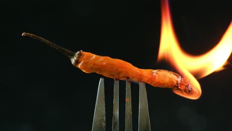 un chile ardiendo en el fuego y liberando gas