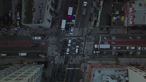 Aerial-birds-eye-overhead-top-down-descending-shot-of-cars-driving-through-road-intersection,-traffic-in-streets-on-city.-Manhattan,-New-York-City,-USA