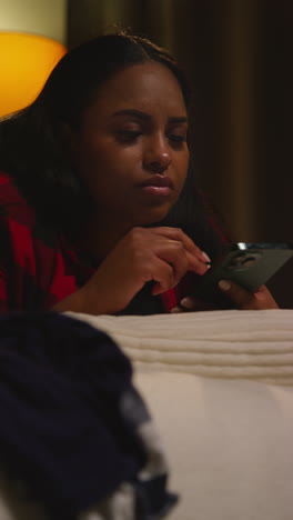 woman texting on phone in bed at night