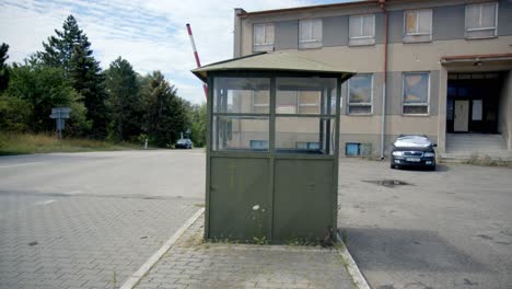 empty street with an old guard house and barrier gate, soviet border post between austria and czech republic - panning