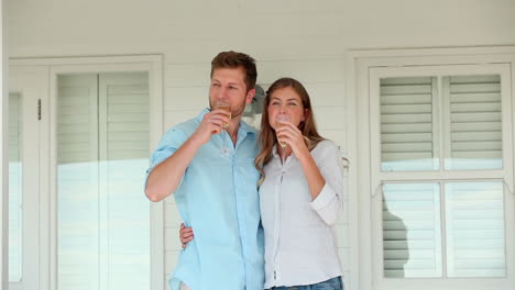 man and a woman clinking glasses of champagne before holding each other