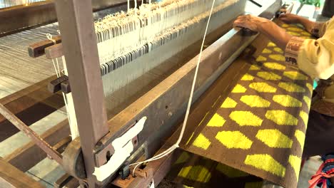 artisan weaving silk fabric on a loom