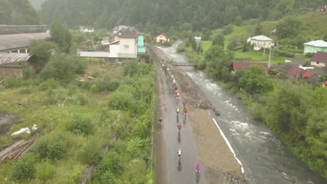 Vista-Aérea-De-La-Carrera-Ciclista-Tura-Cu-Copaci-En-Colibita,-Rumania-Con-Drones-Volando-Hacia-Adelante