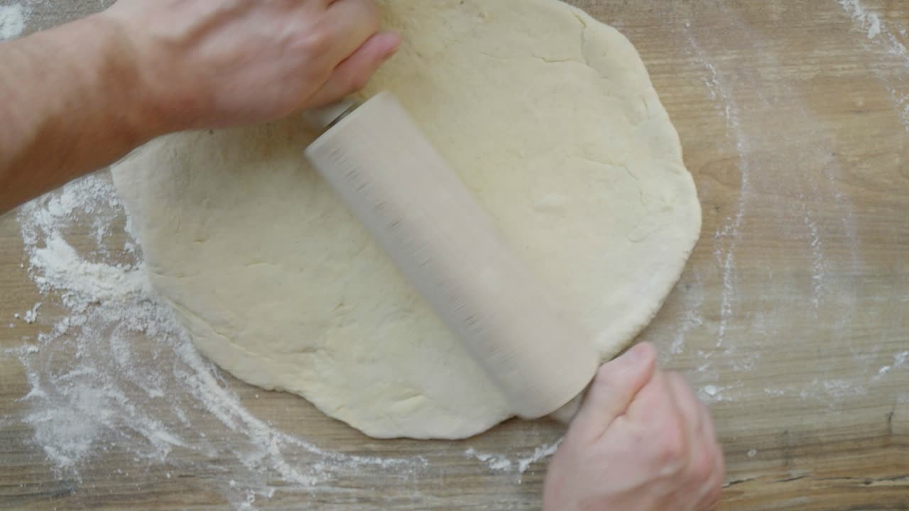 una vista de la masa enrollada mientras se trabaja en la preparación de la masa para panes caseros