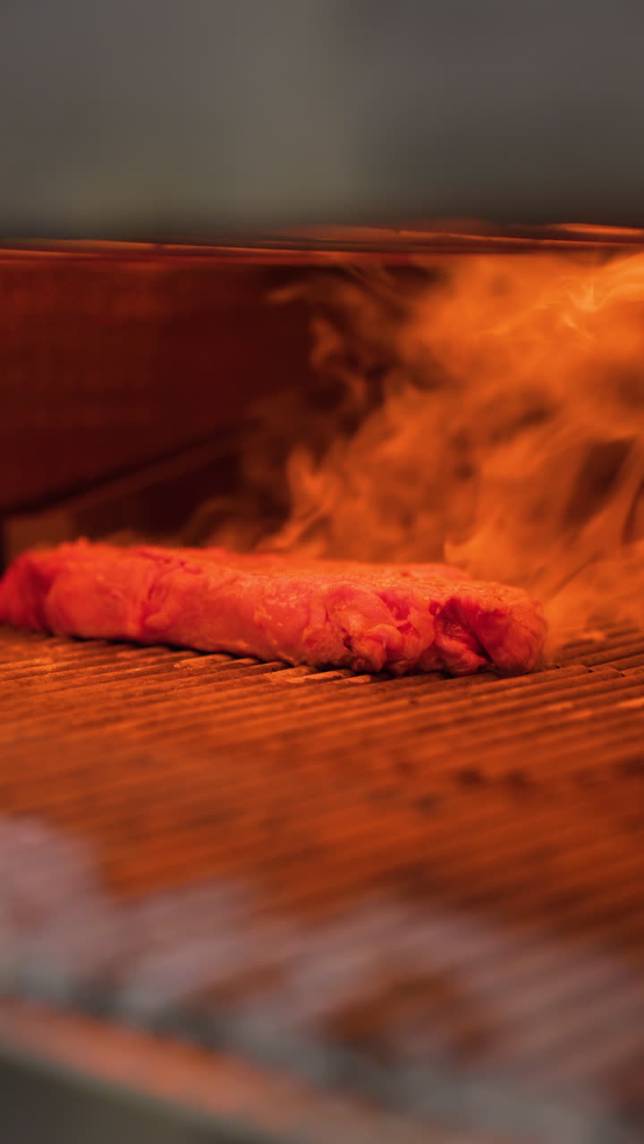 Bife de contrafilé sendo preparado em uma grelha quente, com chamas e fumaça subindo. Preparando uma deliciosa carne grelhada com calor
