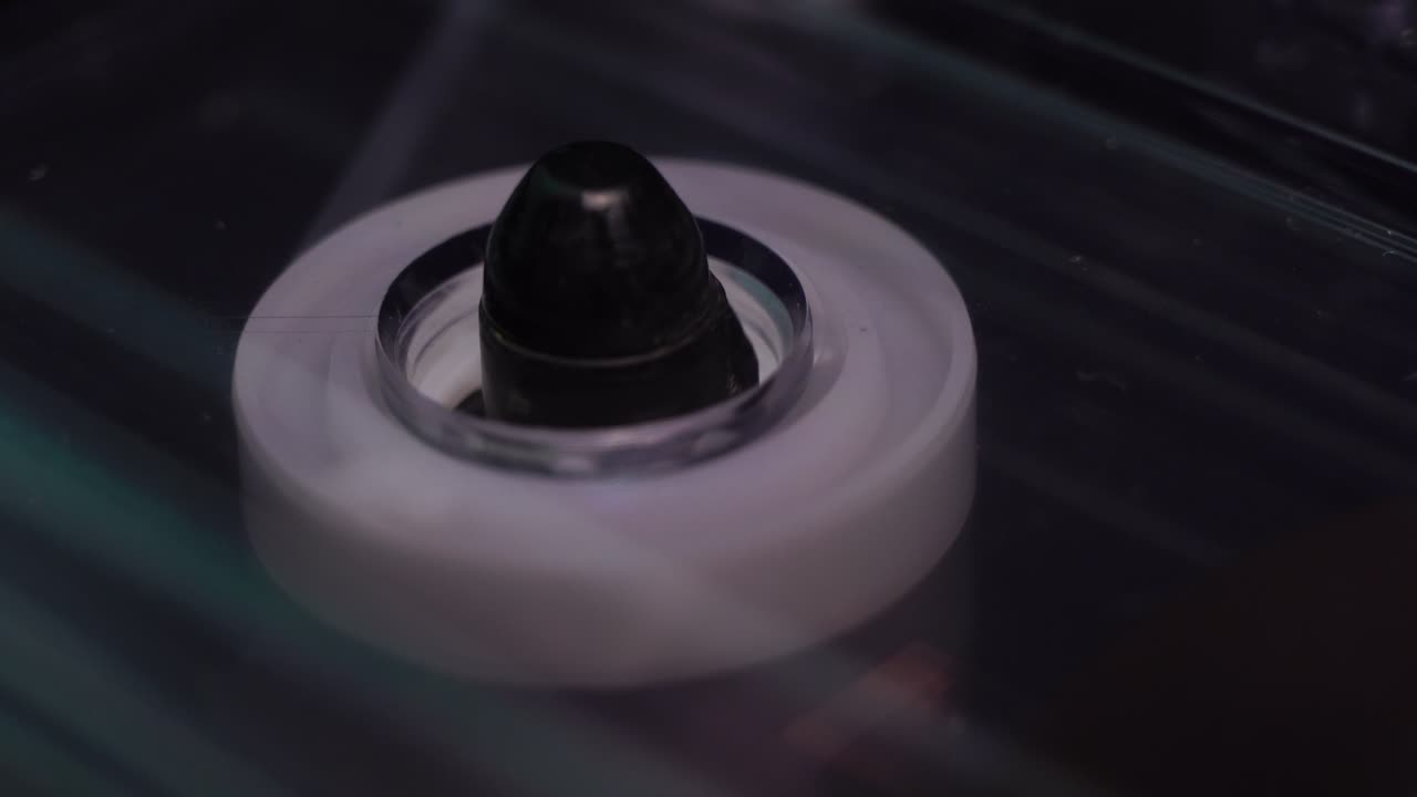 투명한 오디오 카세트 테이프와 릴이 재생을 시작하여 가까이 회전합니다.