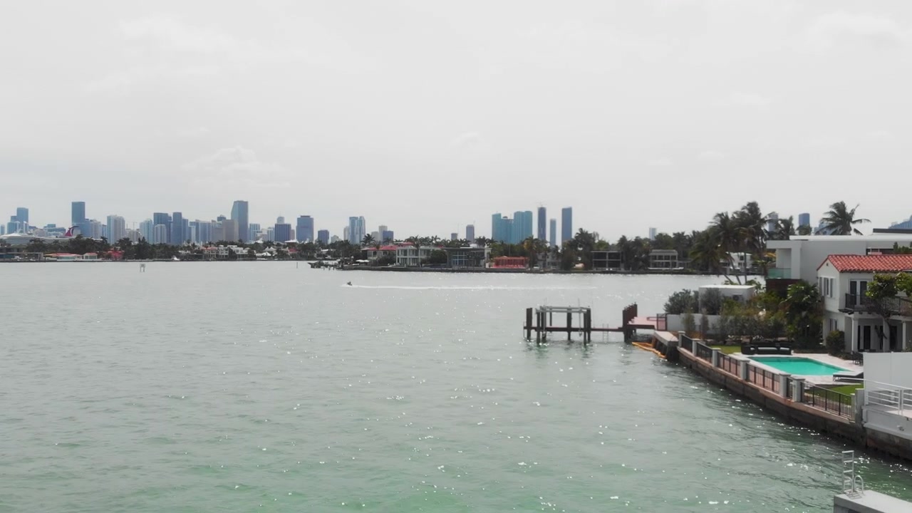 Il drone si allontana sopra la Baia di Miami con moto d'acqua e viste sullo skyline.