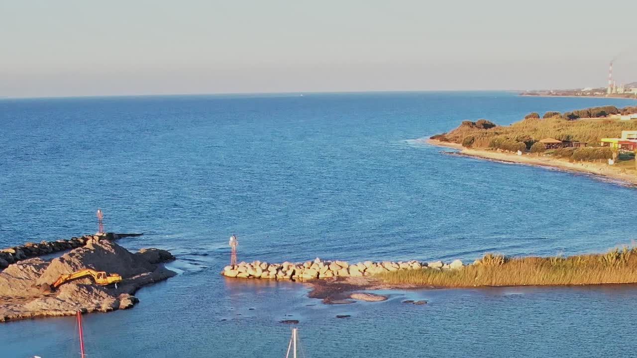 Vista della costa di Rodi con barche e rocce in acqua limpida