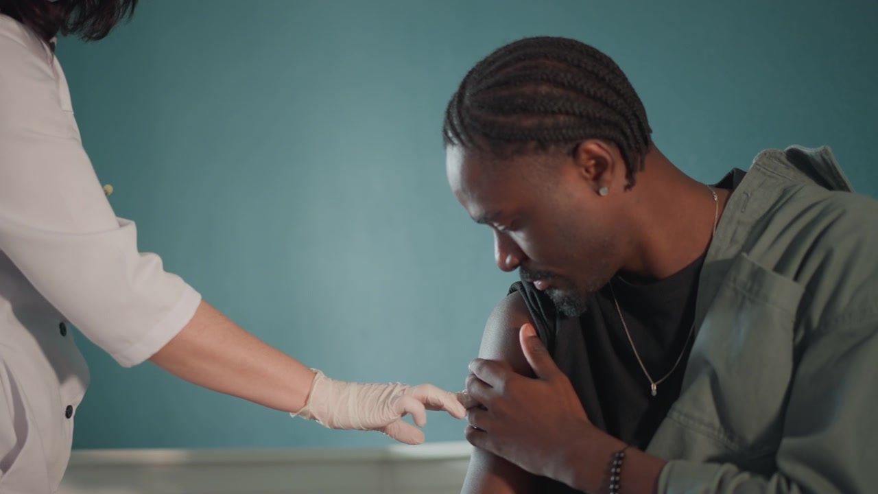 Patient gets vaccination. Man receives immunization comfort. Male individual receives reassuring vaccination process. Male recipient is comforted and reassured throughout immunization procedure
