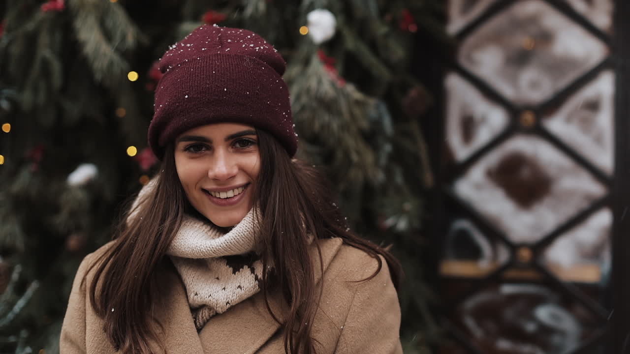 Woman in winter attire near Christmas tree