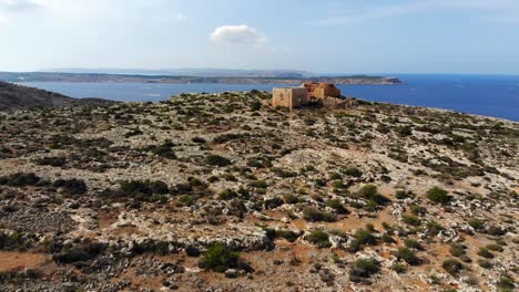 gorgeous aerial drone video from malta, mellieha, selmun, passing over the historical ghajn hadid tower and ending in the magnificent bay behind it