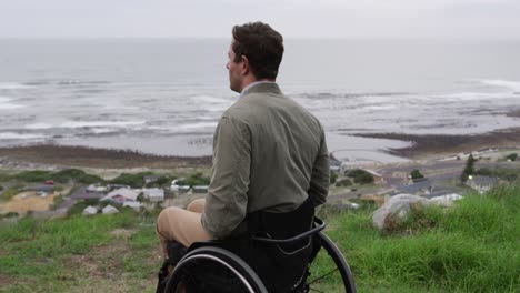 hombre en silla de ruedas mirando al mar