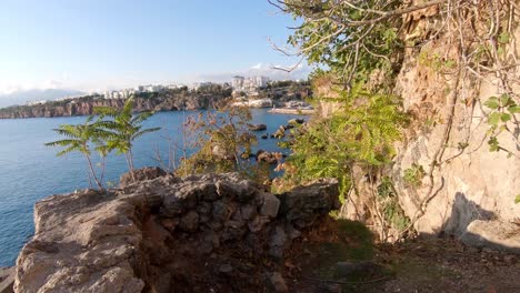 People-walking-point-of-view,-coast-of-Antalya,-bay-and-Mediterranean-ocean,-Turkey