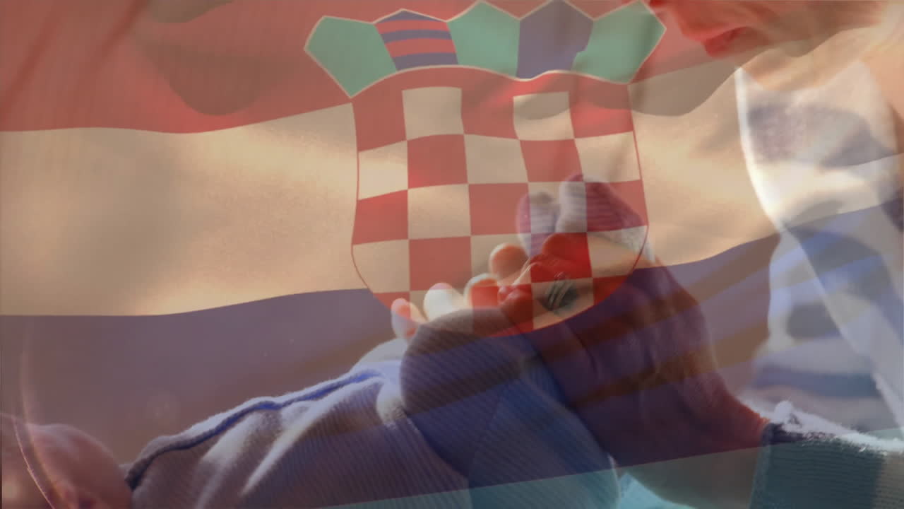 Holding baby socks with Croatian flag overlay, person symbolizing family pride