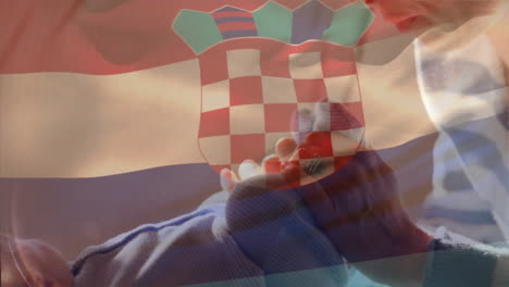 holding baby socks with croatian flag overlay, person symbolizing family pride