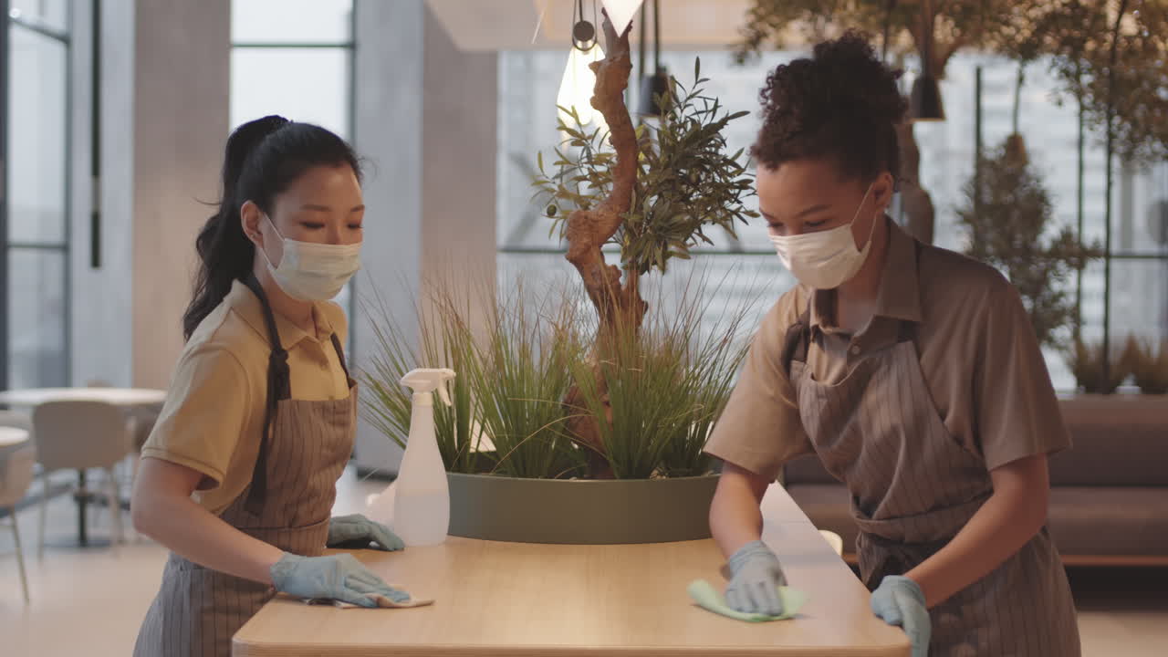 Female Cafe Workers Cleaning Table