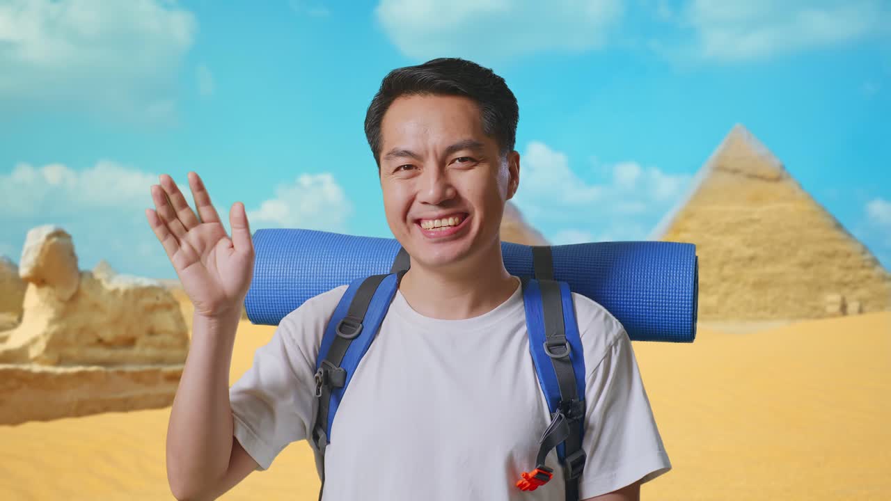 Close Up Of Asian Male Hiker With Mountaineering Backpack Waving Hand And Saying Bye While Traveling In Pyramid Of Giza