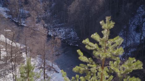 Wide-Shot-of-River-Running-in-a-Valley-on-a-Bright-Winter-Day-in-Vilnius