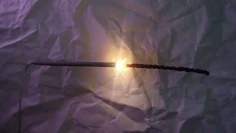 primer plano de la luz de fuegos artificiales bengala y un fondo de papel rayado