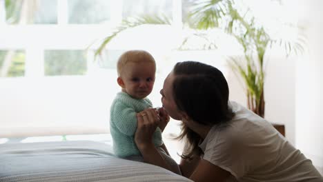 happy young mom kissing her baby daughter