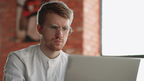 portrait of freelancer in cafe man is working with laptop surfing internet and chatting online