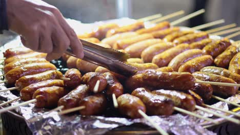 turning sausages on a grill with tongs