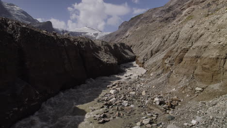 Aerial-view-of-alpine-glacier-lake-stream-from-Pasterze-Glacier-at-the-foot-of-the-Grossglockner-Mountain-in-High-Tauern-National-Park,-Austria