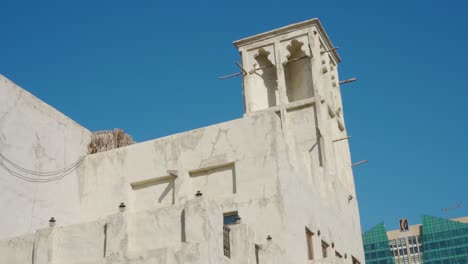 Building-With-Wind-Tower-Against-Blue-Sky---Al-Fahidi-Historical-District-In-Dubai---low-angle