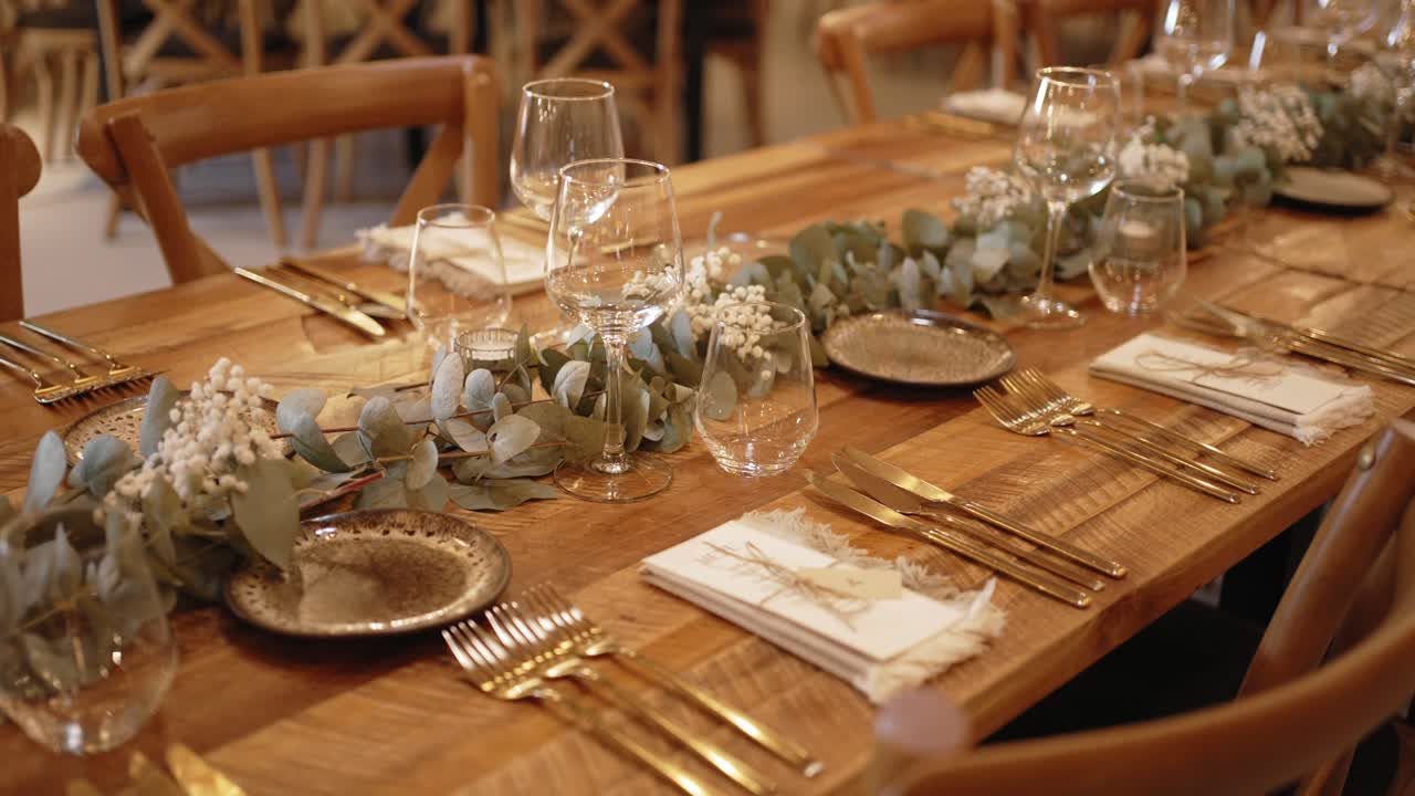 elegant wedding table set with gold cutlery, eucalyptus garland and rustic wood detail