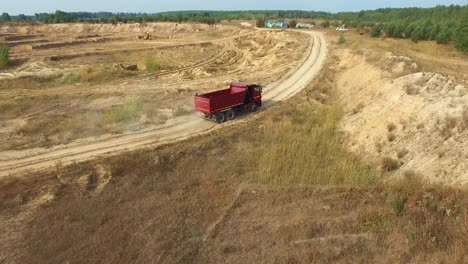 camión de basura rojo en una cantera de arena